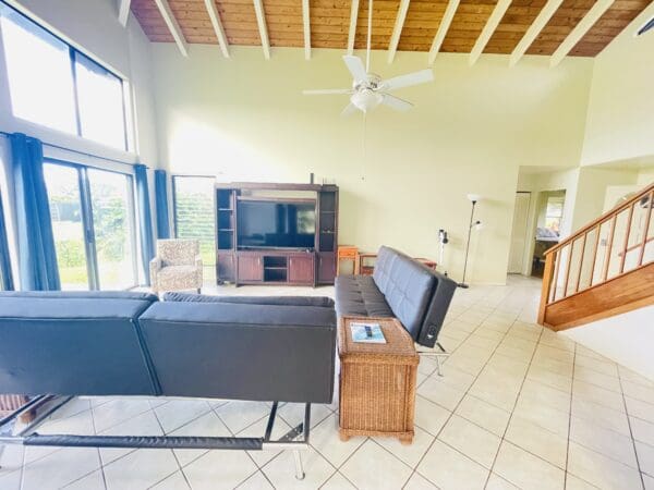 A living room with a couch, television and a table.