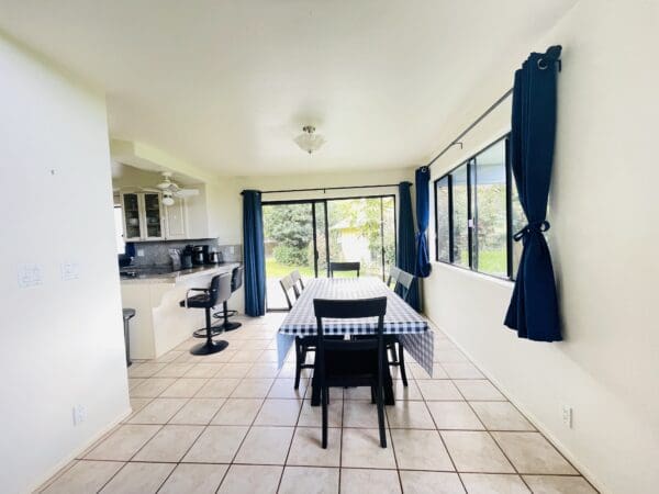 A dining room with blue curtains and white tile floors.