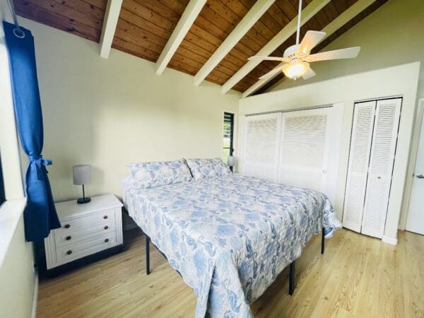 A bedroom with a bed, dresser and closet.