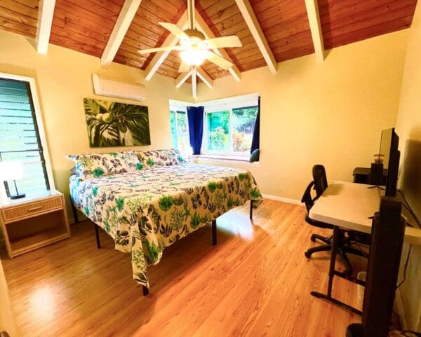 A bedroom with a bed, desk and chair.