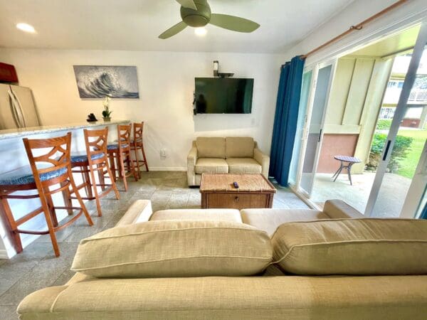 A living room with couches and chairs, tv on the wall.