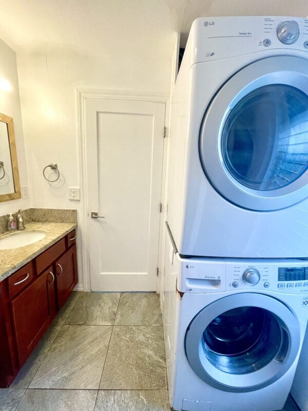 A bathroom with two washing machines and a sink.