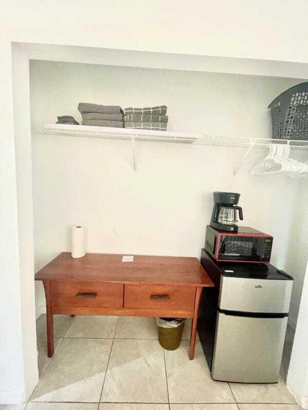 A small kitchen with a microwave, toaster oven and coffee maker.