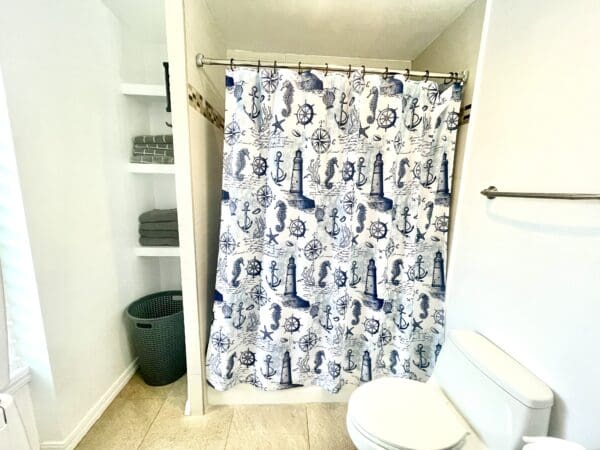 A bathroom with a shower curtain and toilet.