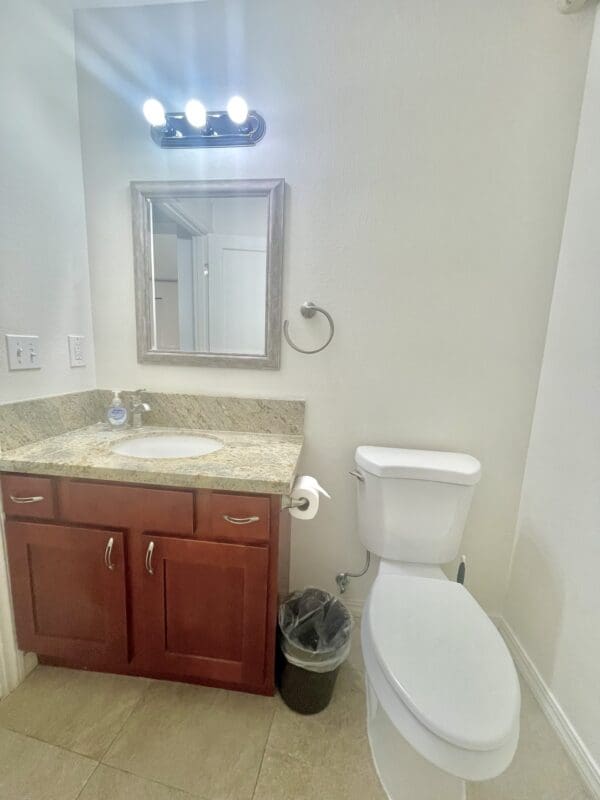 A bathroom with a sink, mirror and toilet.