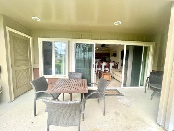 A patio table and chairs on the porch of a house.