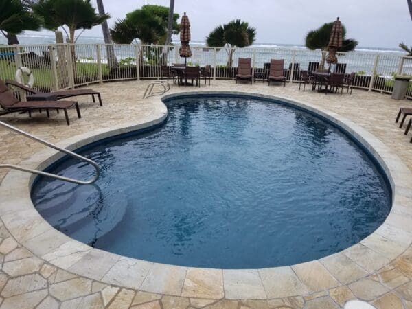 A pool with chairs and umbrellas in the middle of it.