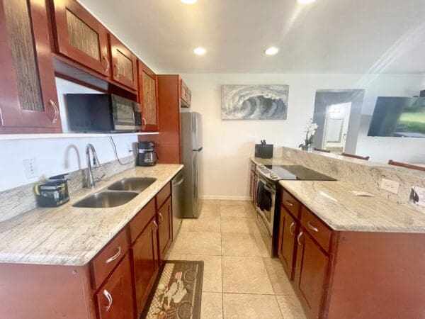 A kitchen with a sink, microwave and refrigerator.