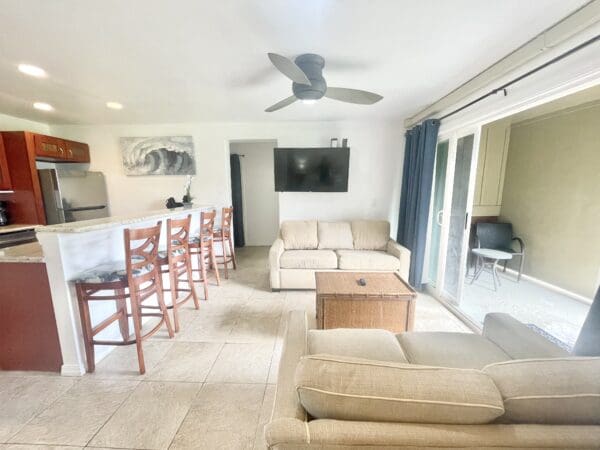 A living room with couches and chairs, a table and a television.