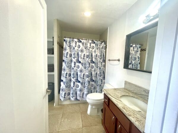 A bathroom with a toilet, sink and shower.