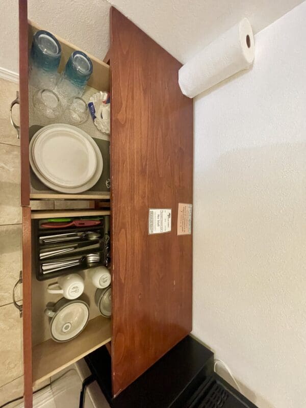 A wooden cabinet with many dishes in it