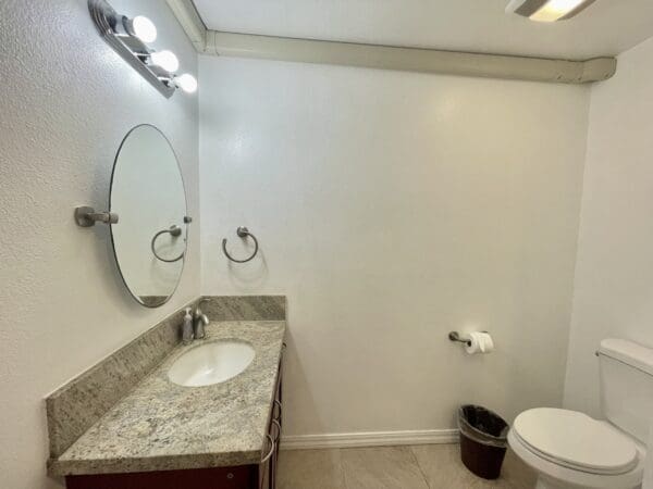 A bathroom with a sink, mirror and toilet.