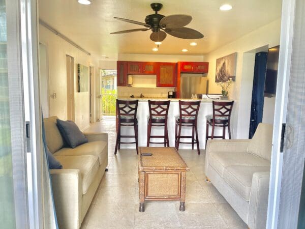 A living room with white couches and chairs.