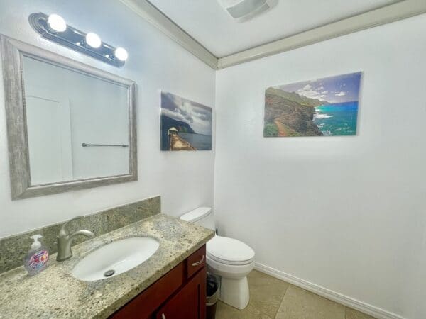 A bathroom with a sink, mirror and toilet.