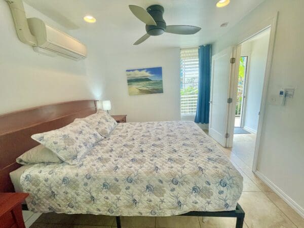 A bed room with a large bed and a fan