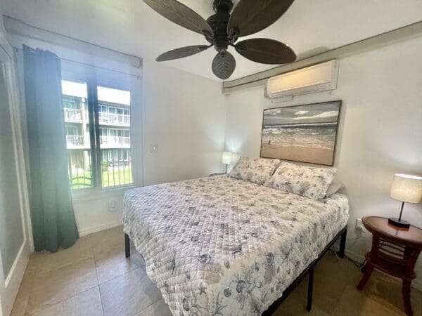 A bedroom with two beds and a fan in the ceiling.