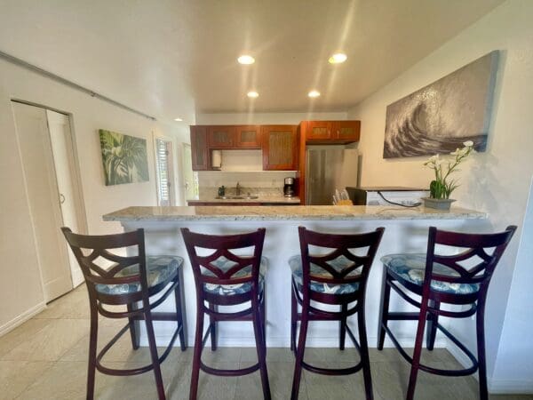 A kitchen with a bar and chairs in it