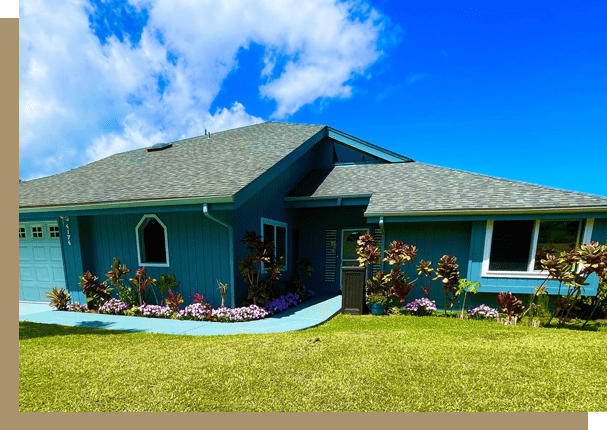 A blue house with flowers in the yard.