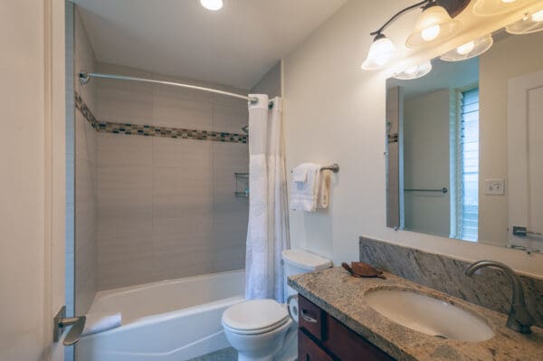 A bathroom with a toilet, sink and tub.