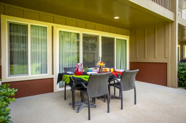 A table with four chairs and a green tablecloth.