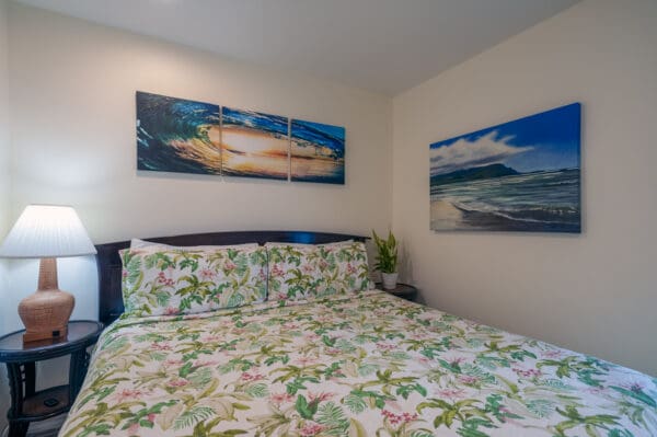 A bedroom with two paintings on the wall.