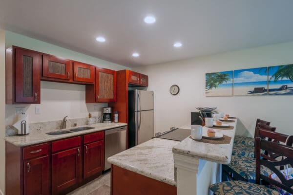 A kitchen with red cabinets and white counter tops.