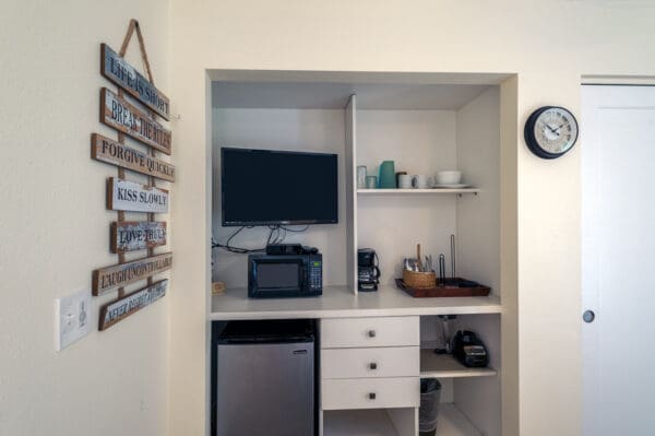 A small kitchen with a refrigerator, microwave and coffee maker.