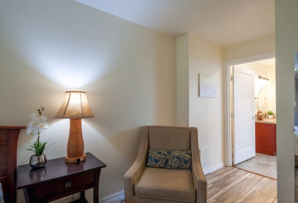 A chair and lamp in the corner of a room.