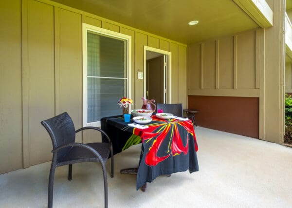 A table with two chairs and a black umbrella