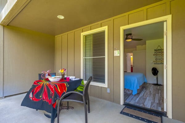 A table and chairs in the middle of an outside porch.