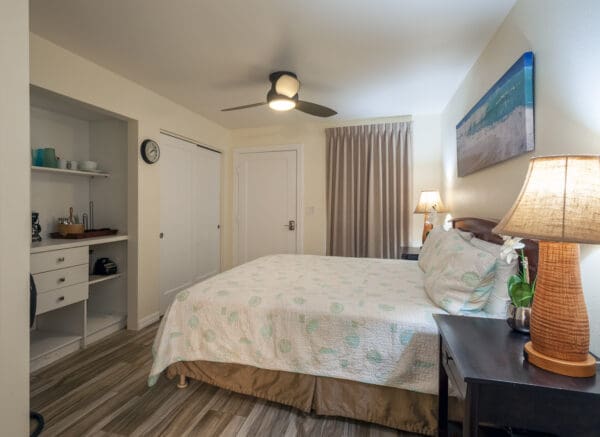 A bedroom with a bed, nightstand and dresser.